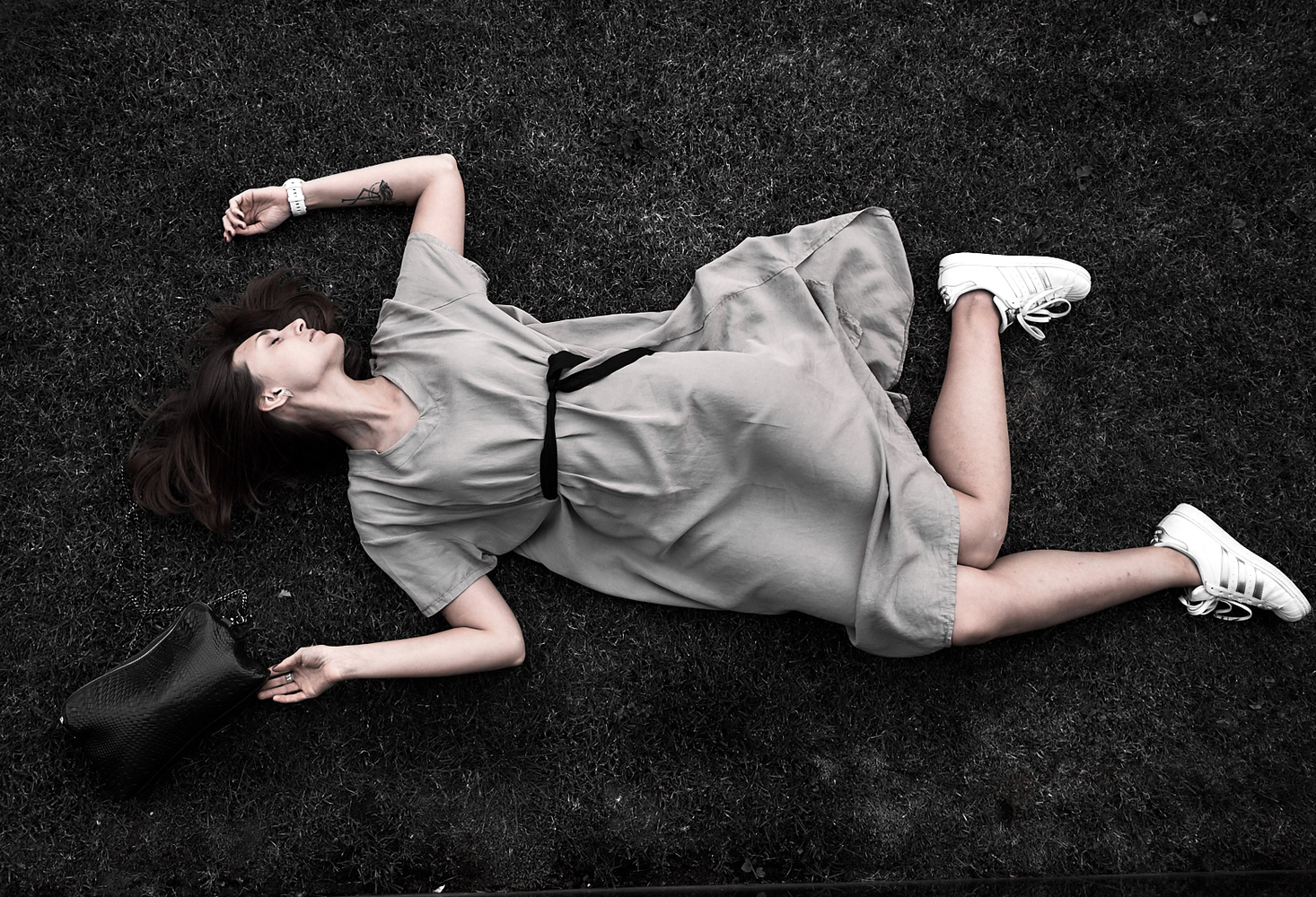 Женщина лежит на траве Модель лежит на траве в расслабленной позе